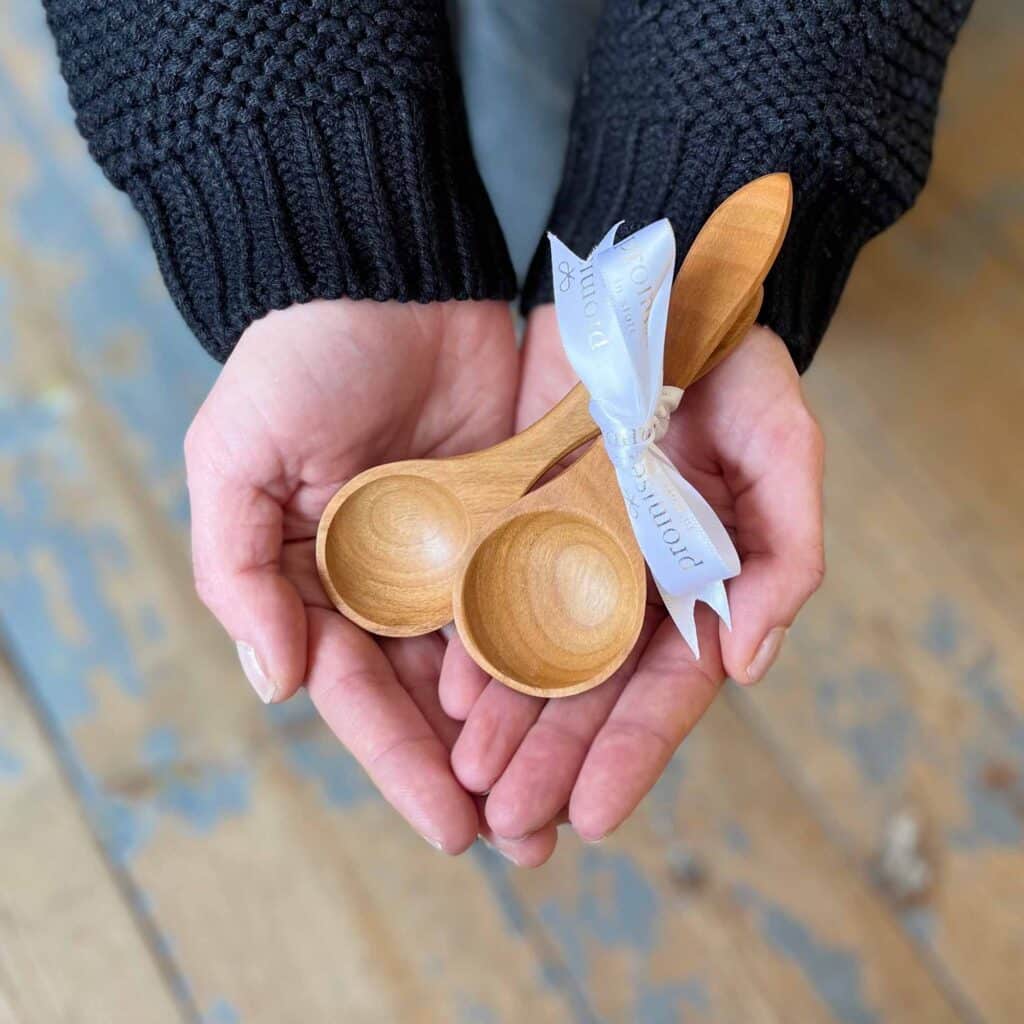 Hands in heart shape holding wooden priceless spoons
