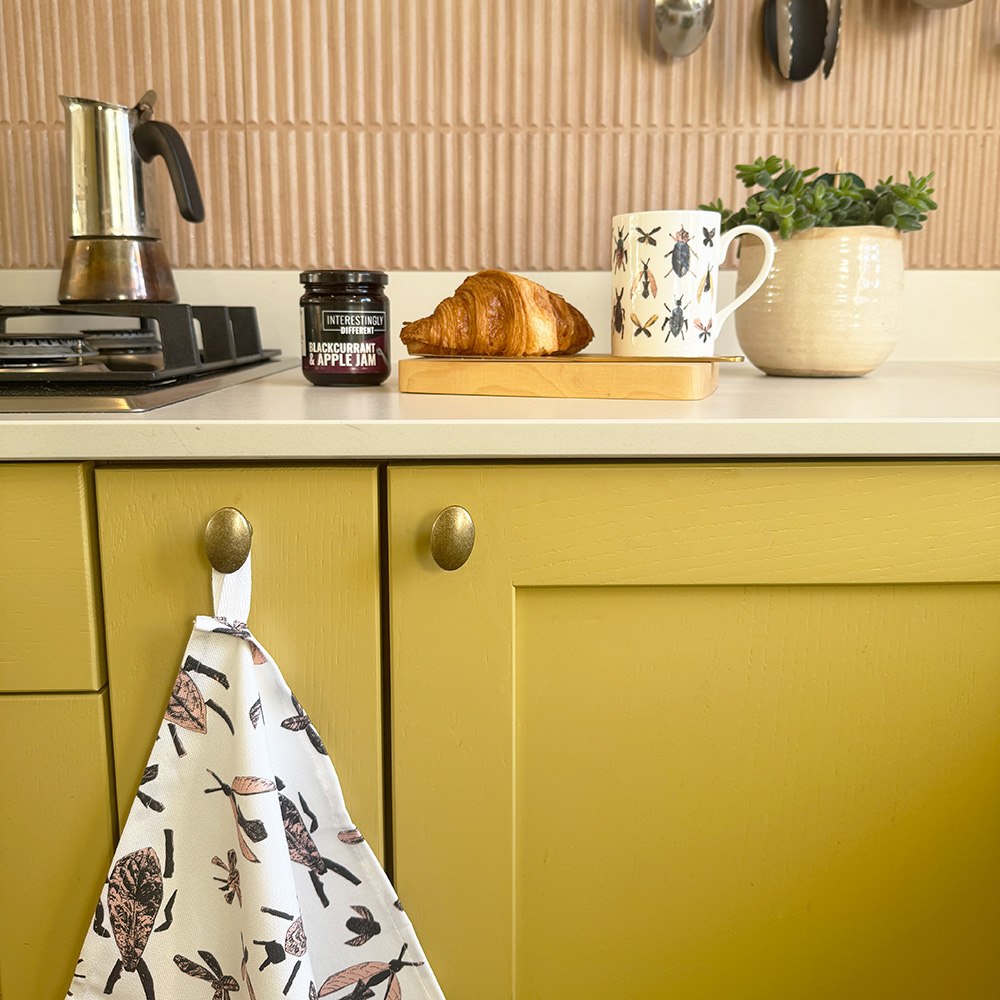 bug tea towel and mug on kitchen counter